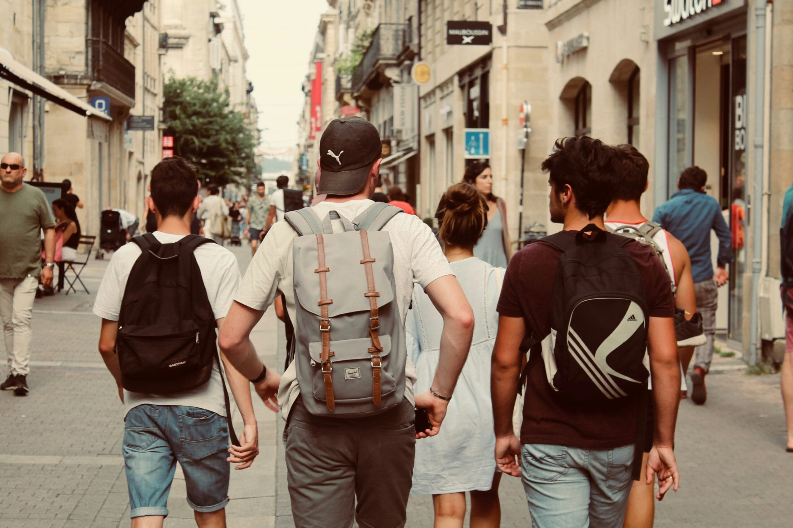 A group of teenage boys walk together down a busy street.